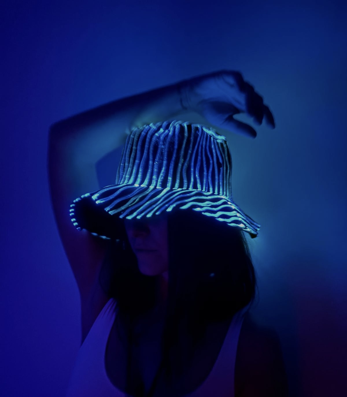 A luminous turquoise fibre-optic hat against a deep blue background